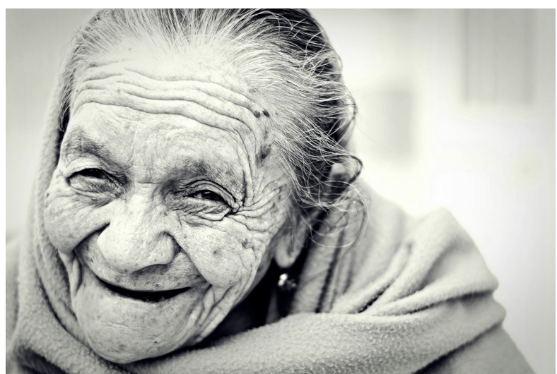 Langlebigkeit und Lebensglück im Alter: Ein lächelndes älteres Gesicht voller Lebensfreude.