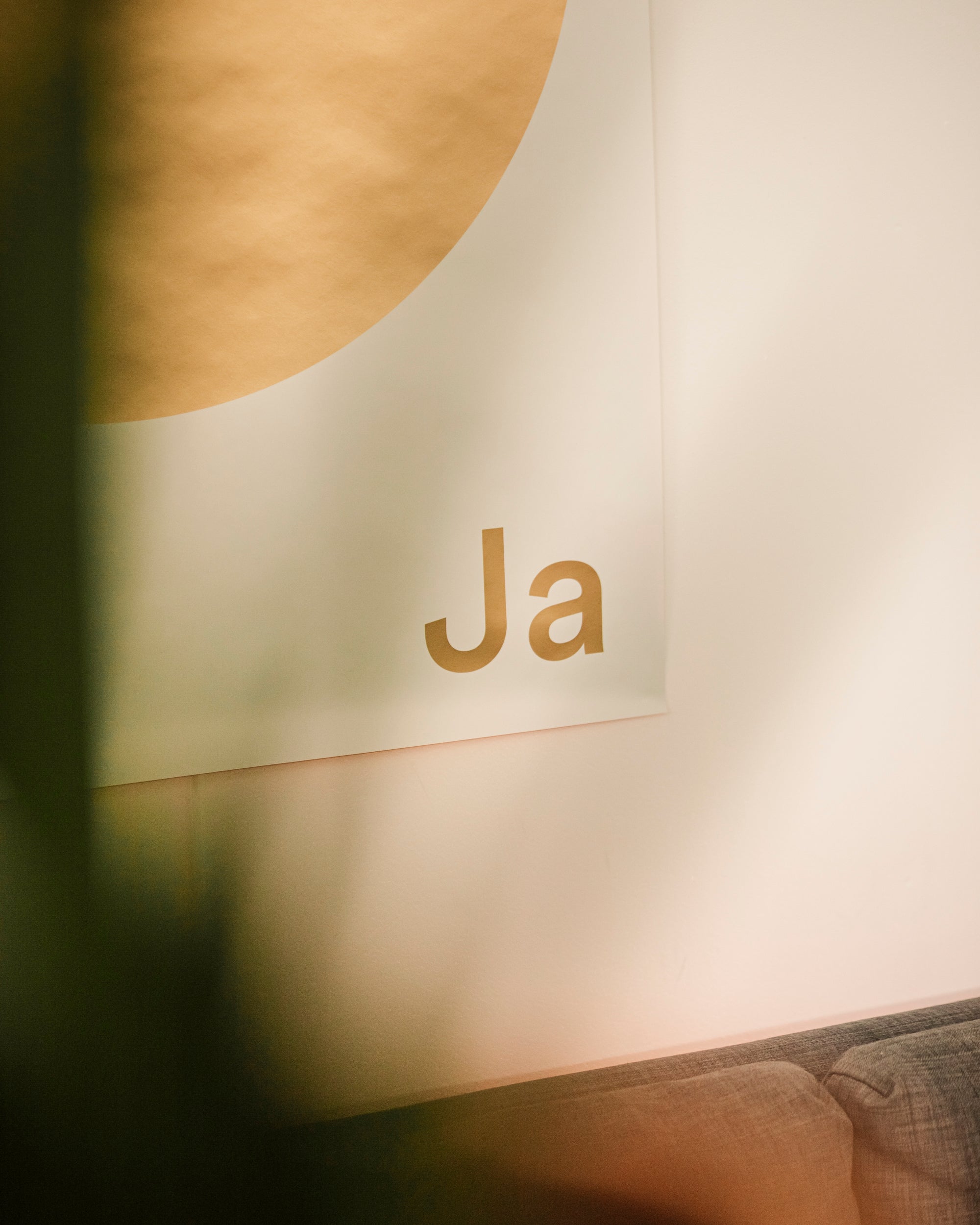 Original Plakat Ja Oui Si with gold lettering 'Ja' on a wall, part of a modern decor.