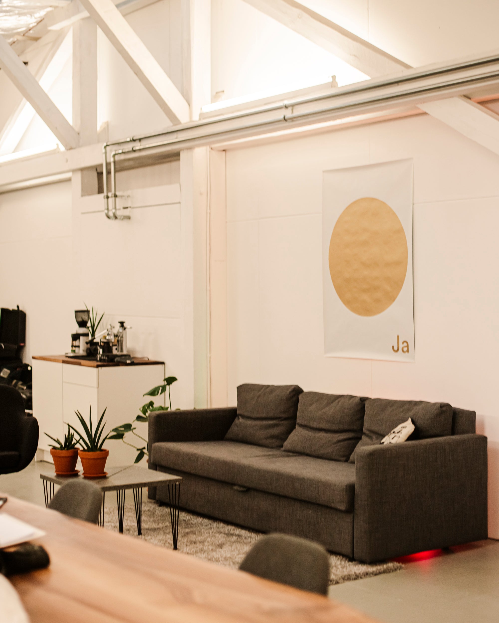 original plakat ja oui si hanging above a modern gray sofa in a bright interior setting.